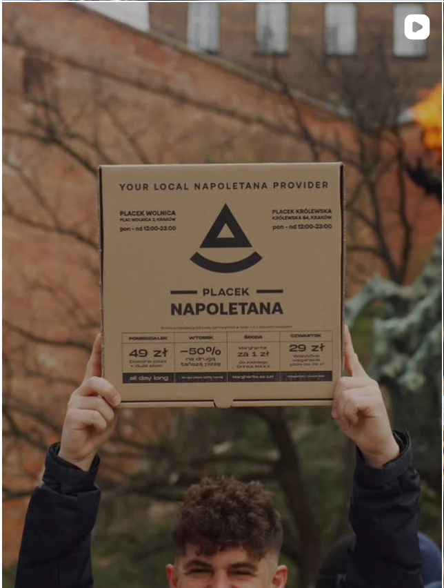 Dłonie trzymają firmowe pudełko pizzy z napisem Napoletana i ceną. Fotografia biznesowa Lublin.