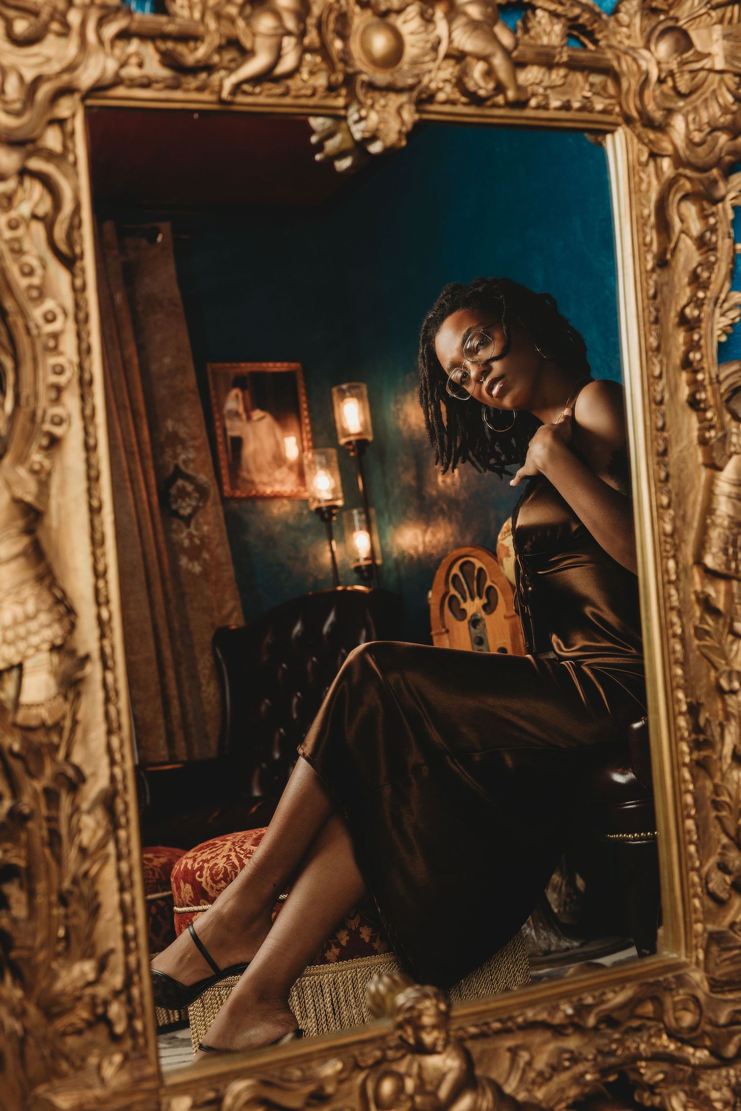 Ornate golden vintage frames display moody boudoir portraits with dramatic lighting and rich brown tones.
