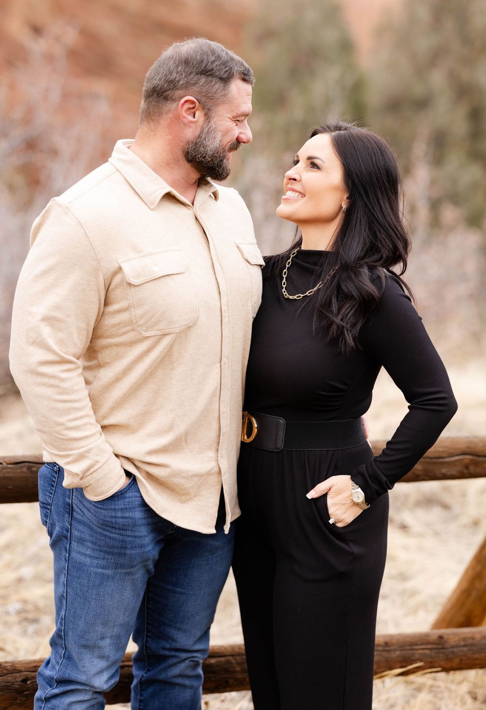 Couple in casual attire share a moment together against desert backdrop.
