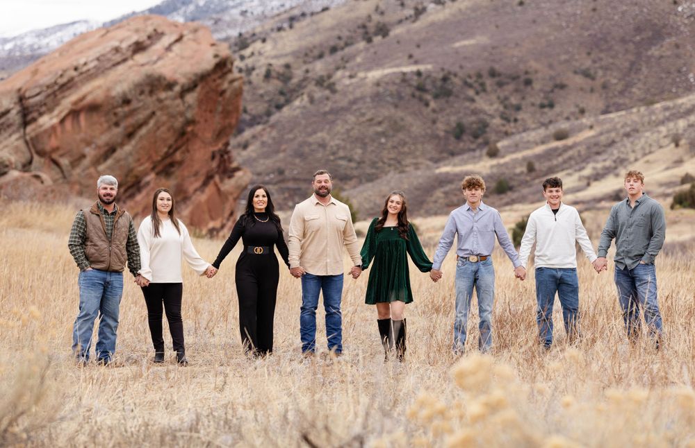 Family portrait in the mountains of Colorado with red rocks and tall grass.