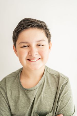 Close-up portraits showing joyful expressions against a white background while wearing a sage green t-shirt.
