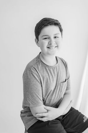 A series of black and white studio portraits showing a young person in a gray t-shirt against a white background.