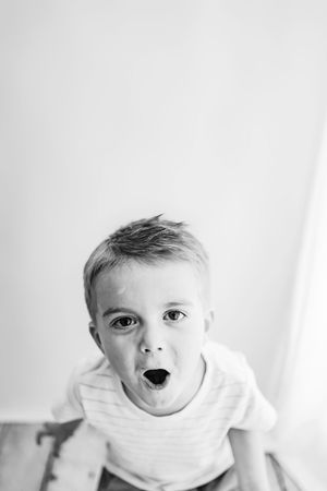 Black and white portrait of excited child making funny expression.