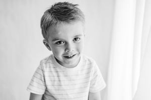 Black and white headshot of child with gentle smile.
