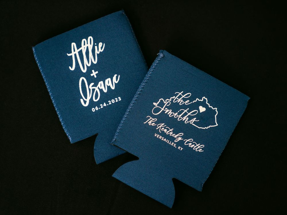 Two navy blue wedding koozies with white script text displayed against dark background.