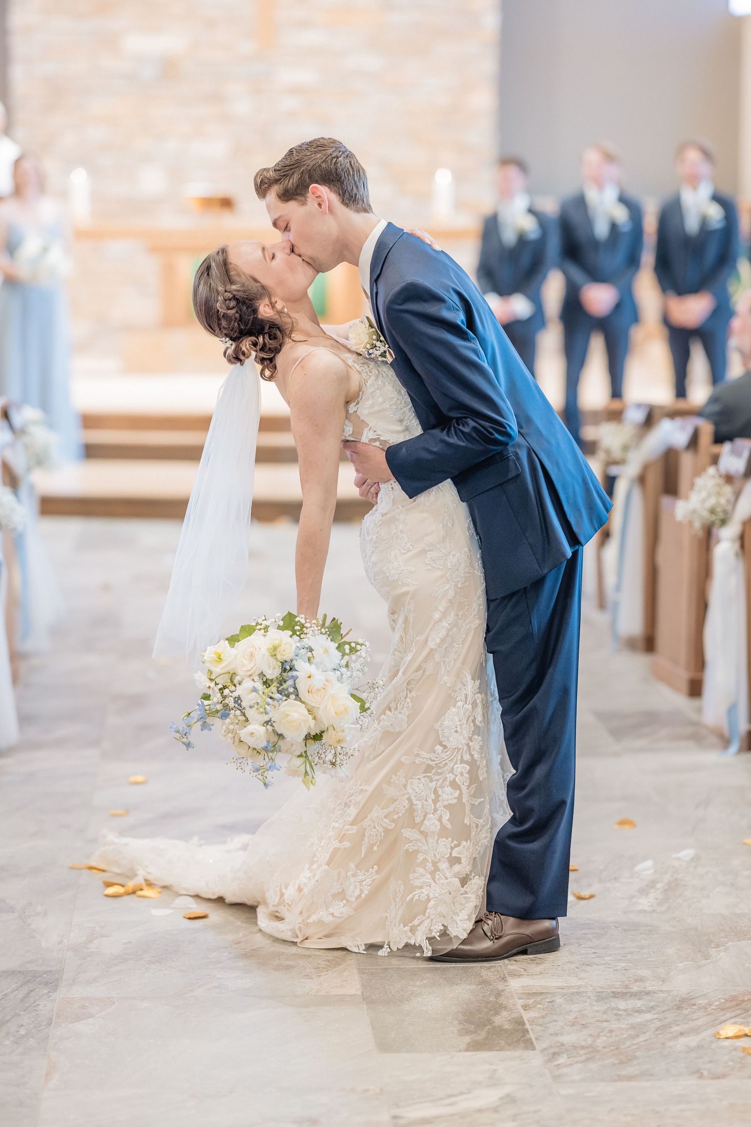 Newlyweds celebrate joyfully while exiting their ceremony under falling confetti.