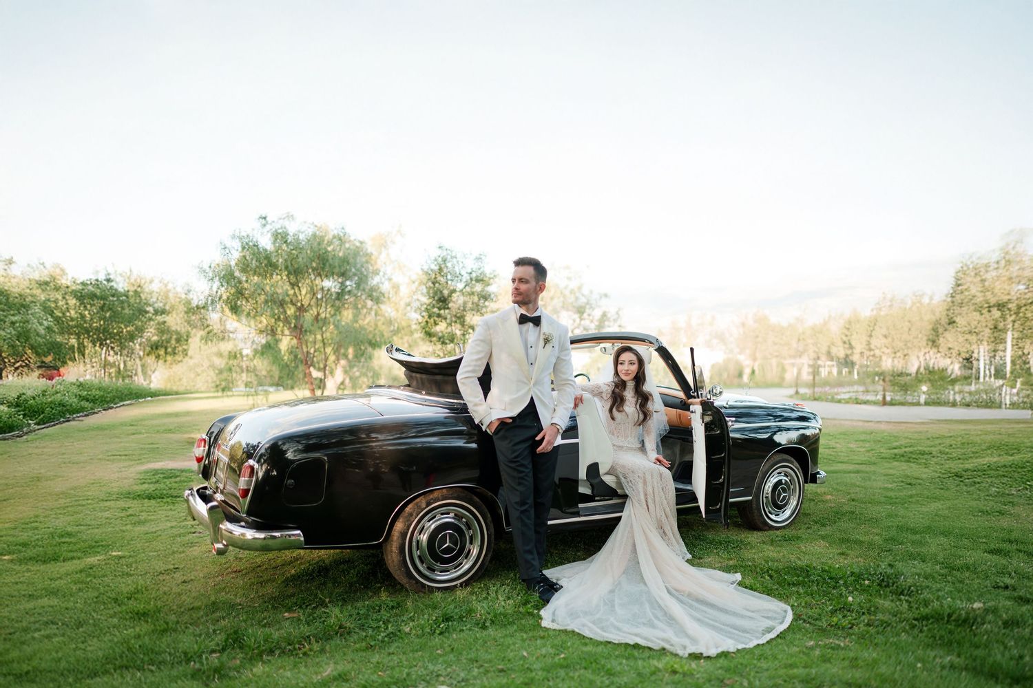 Elegant wedding photography featuring a vintage car in a natural outdoor setting.