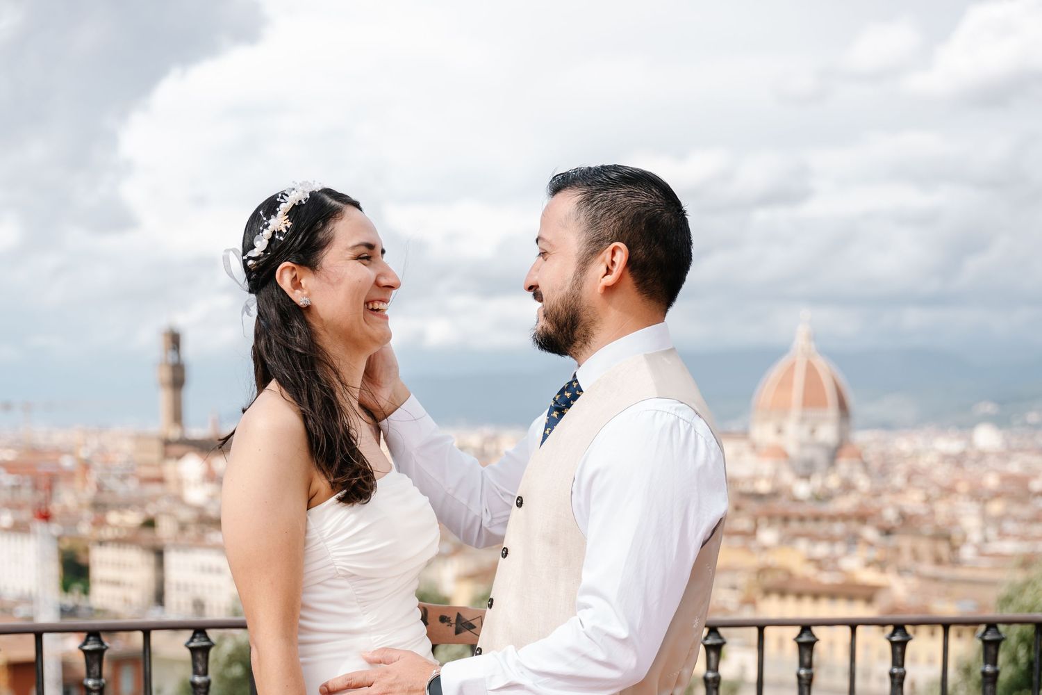 Wedding couple sharing a romantic moment on a terrace overlooking Florence with the Duomo in the background.