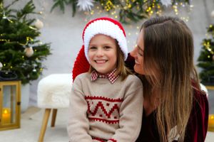 Festive holiday portrait with person in red dress and two in matching fair isle sweaters.