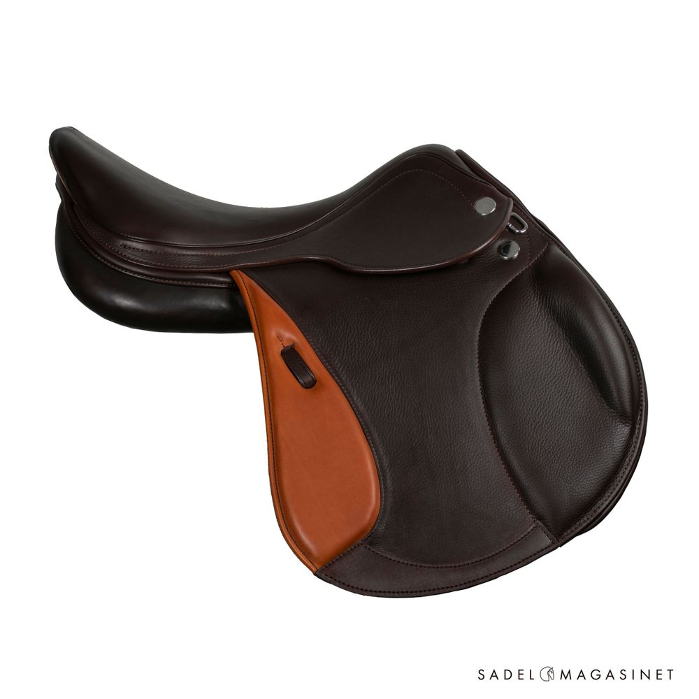 Dark brown leather English jumping saddle with tan knee rolls against white background.
