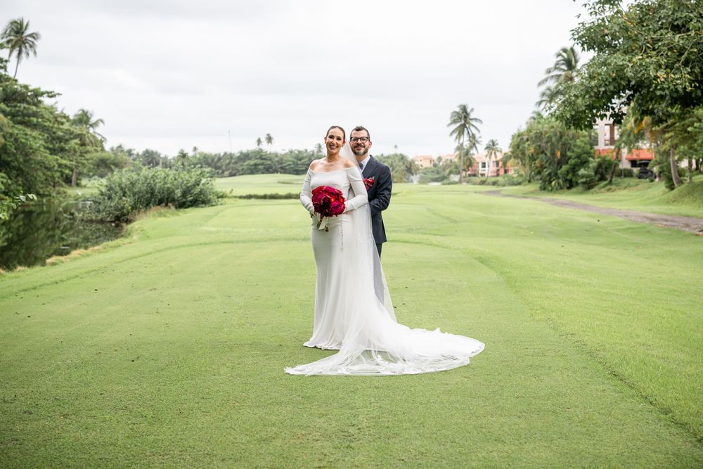 Wedding portrait on a scenic golf course with palm trees and dramatic flowing veil.