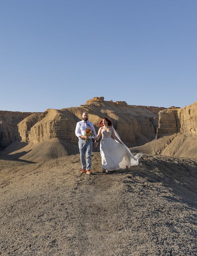 A sequence of photos showing people in white clothing posing on rocky desert terrain against a mountainous backdrop.