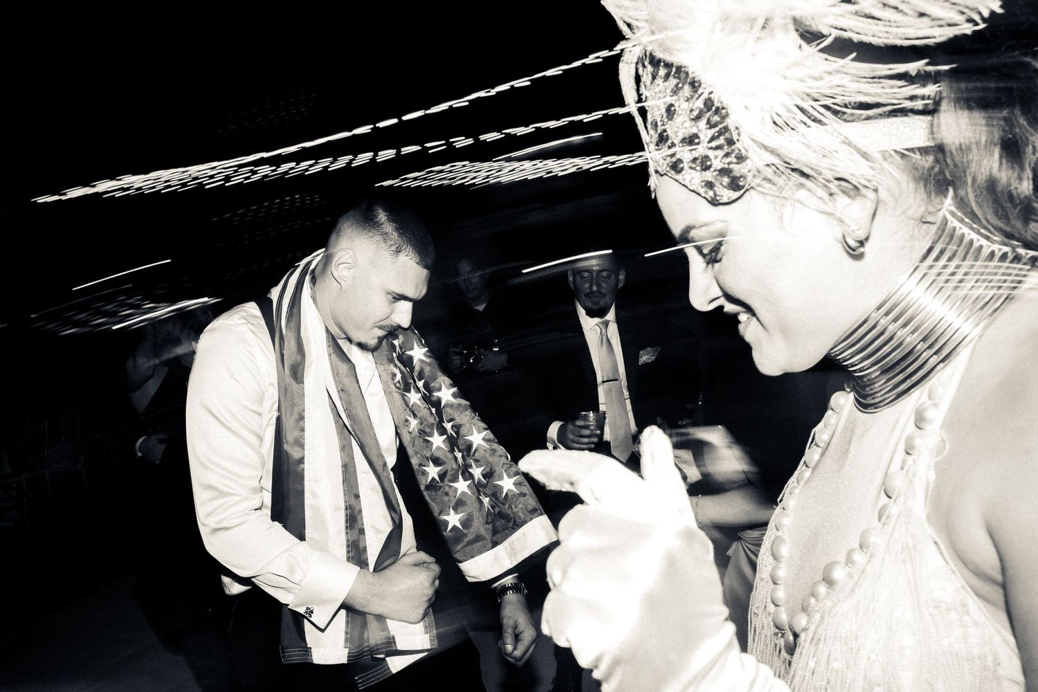 A black and white candid reception photo showing festive wedding celebration moments.