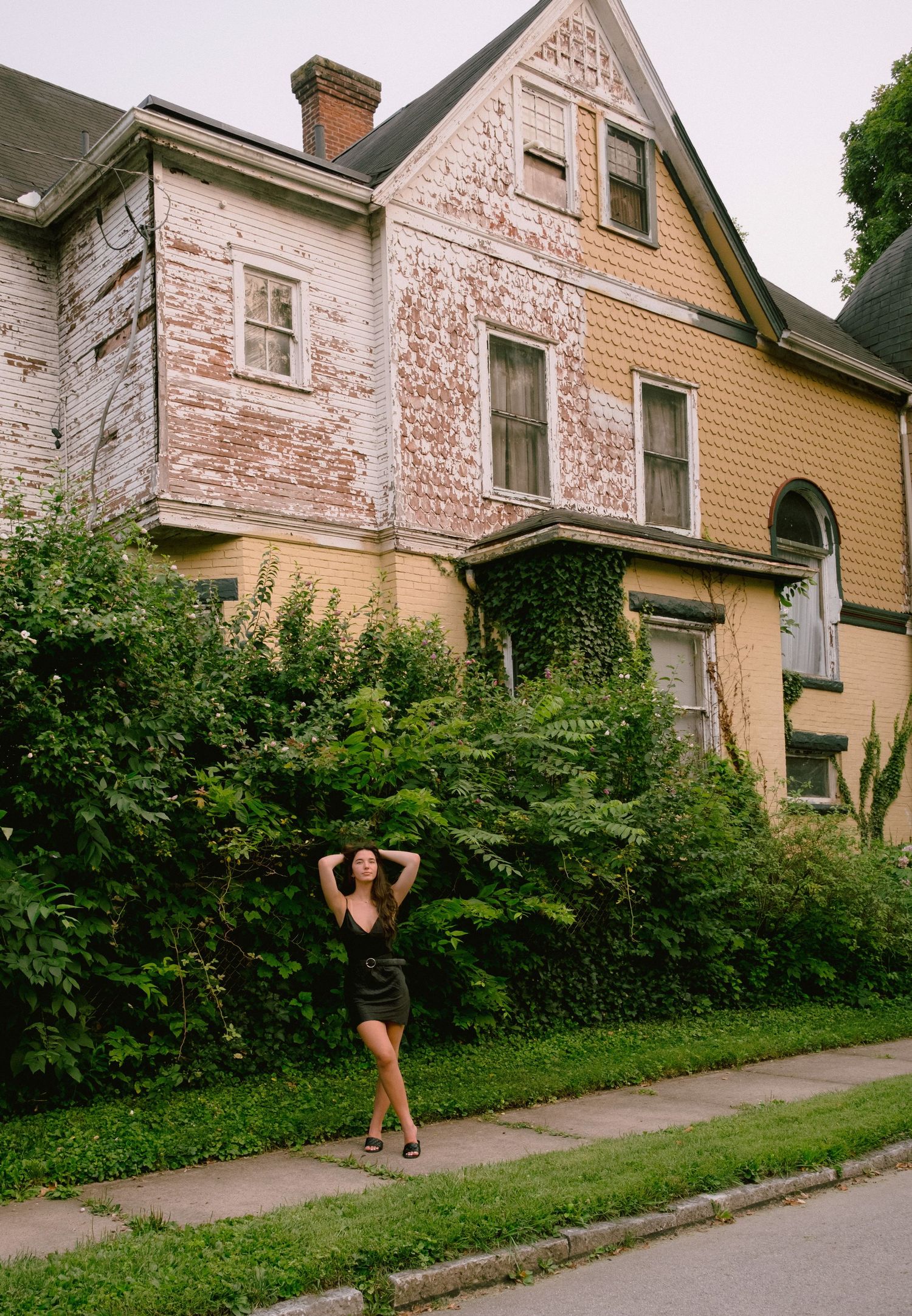 Fashion shoot in front of a weathered vintage Victorian house with peeling paint.