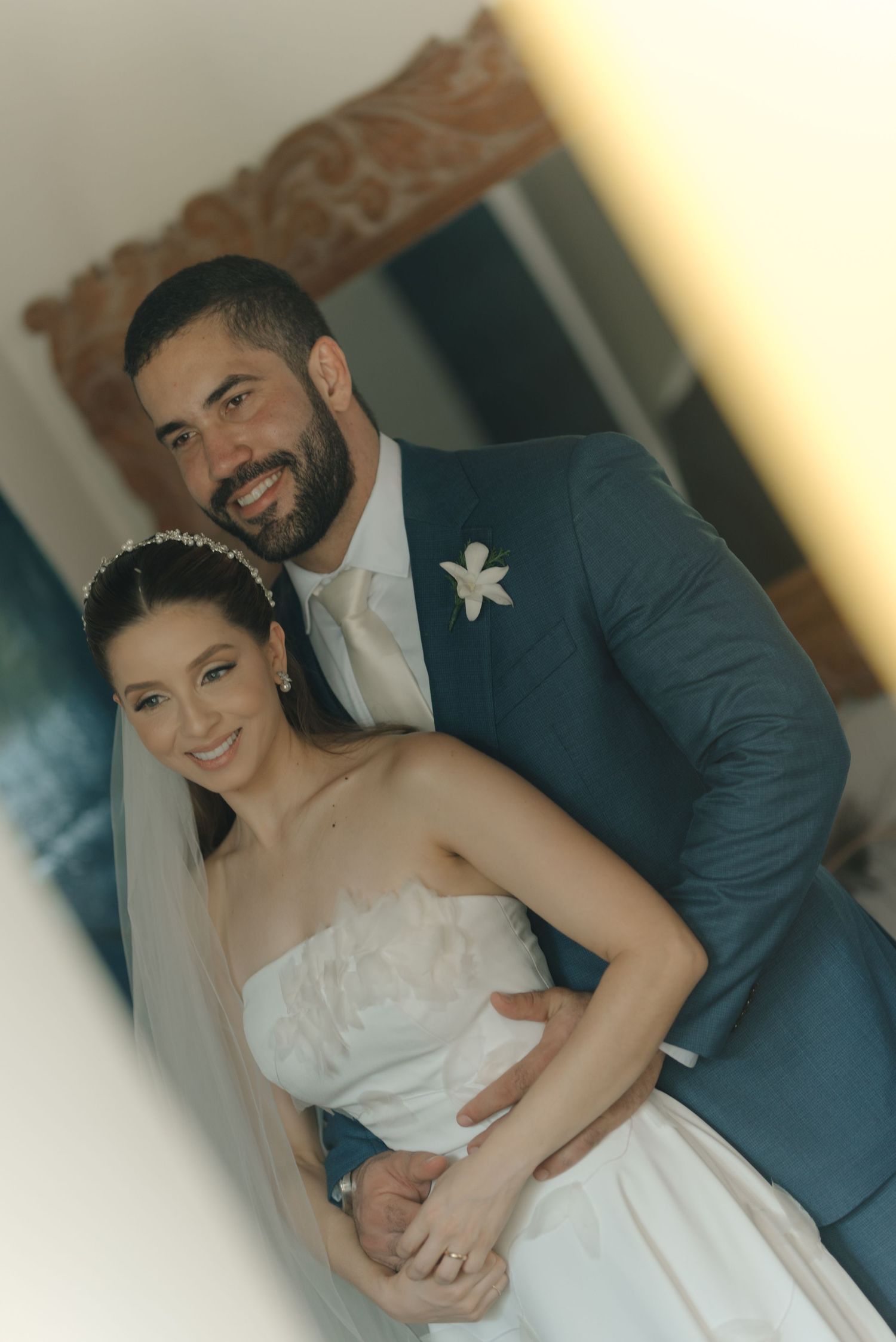 Newlywed couple in traditional wedding attire share an intimate embrace during their wedding reception.
