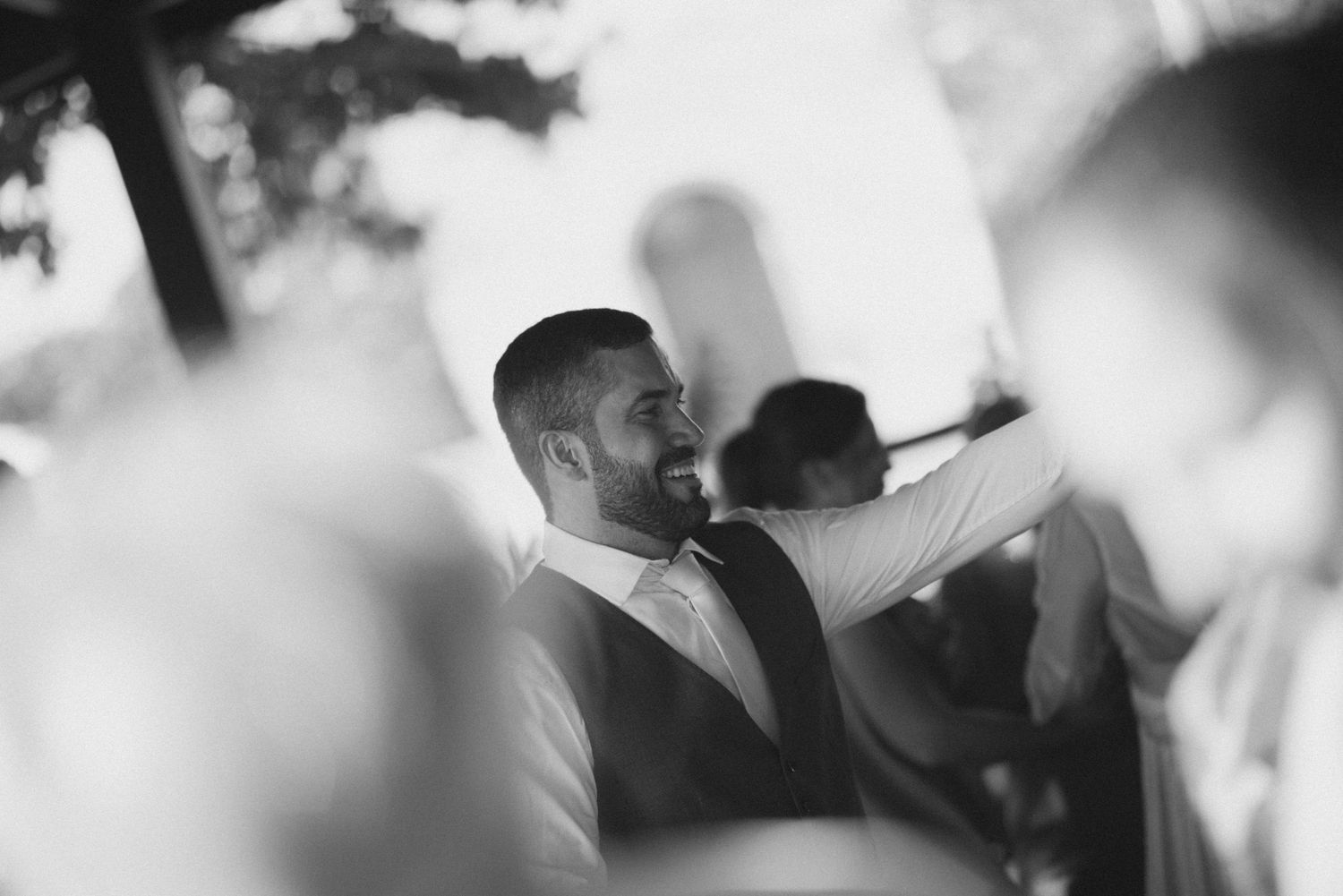 Candid black and white photo of a wedding guest enjoying the reception celebration.