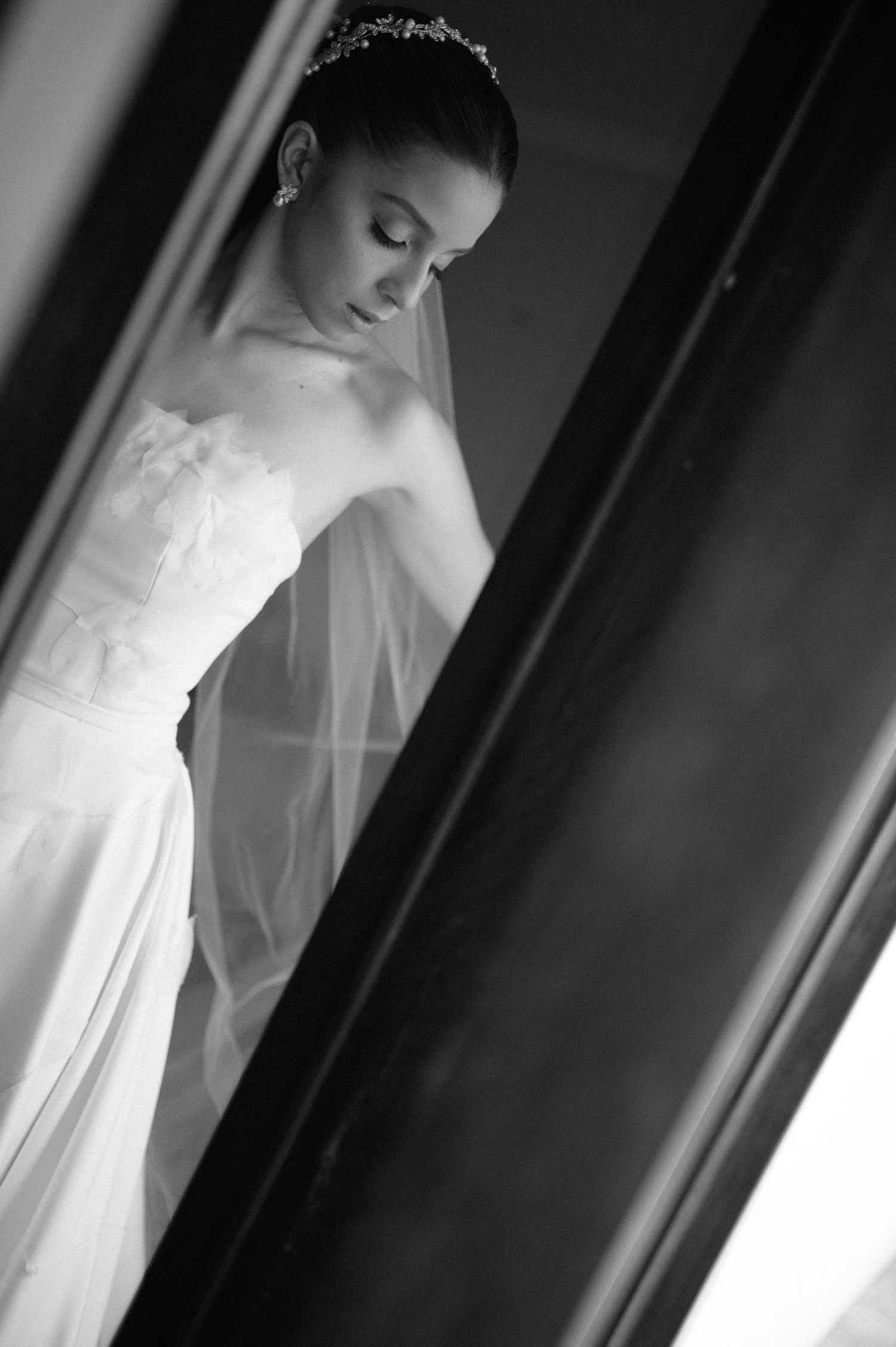 Dramatic black and white portrait of bride in strapless gown and veil.