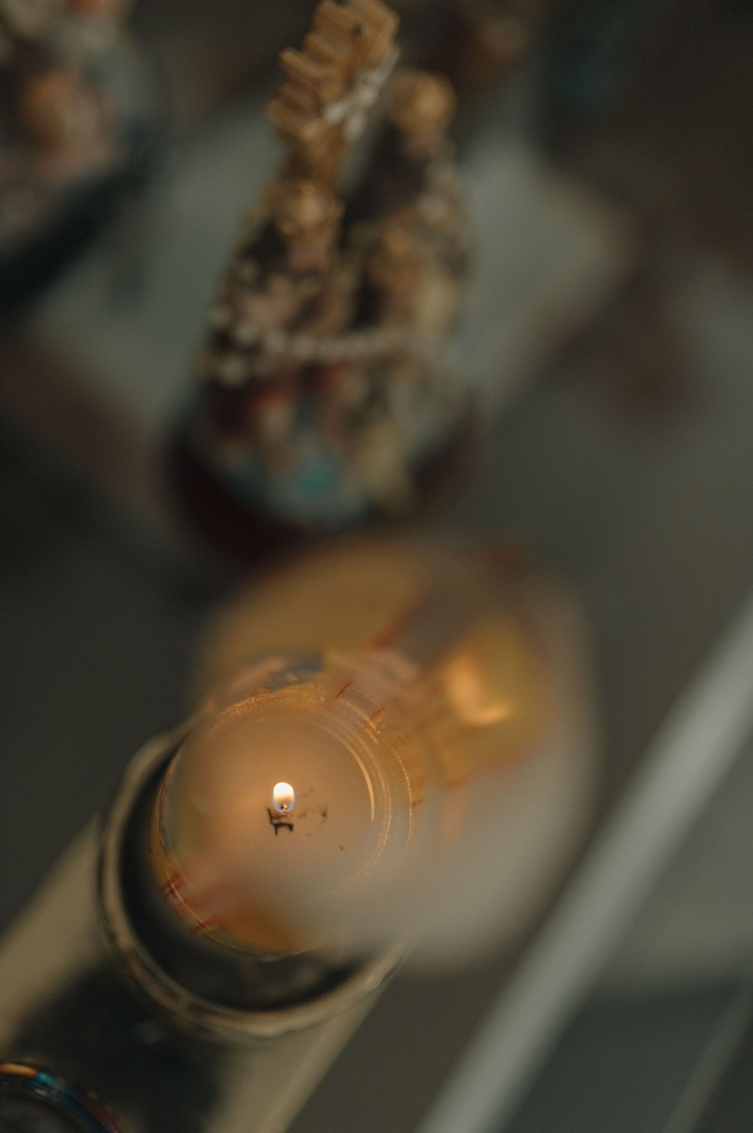 A close-up shot of a lit candle with warm golden bokeh in the background.