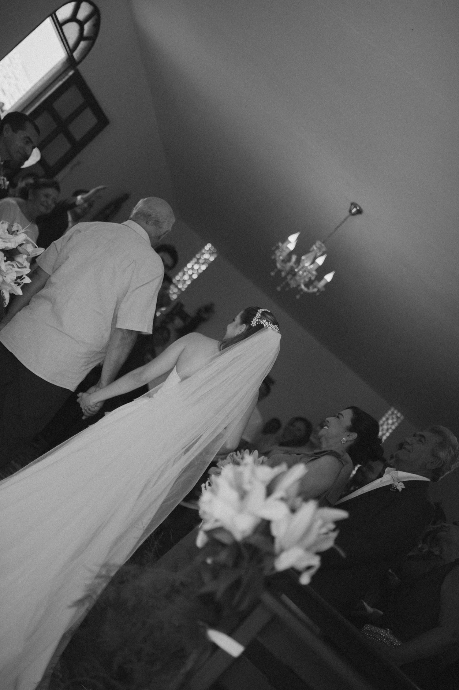 Black and white photo of wedding ceremony with long flowing veil.