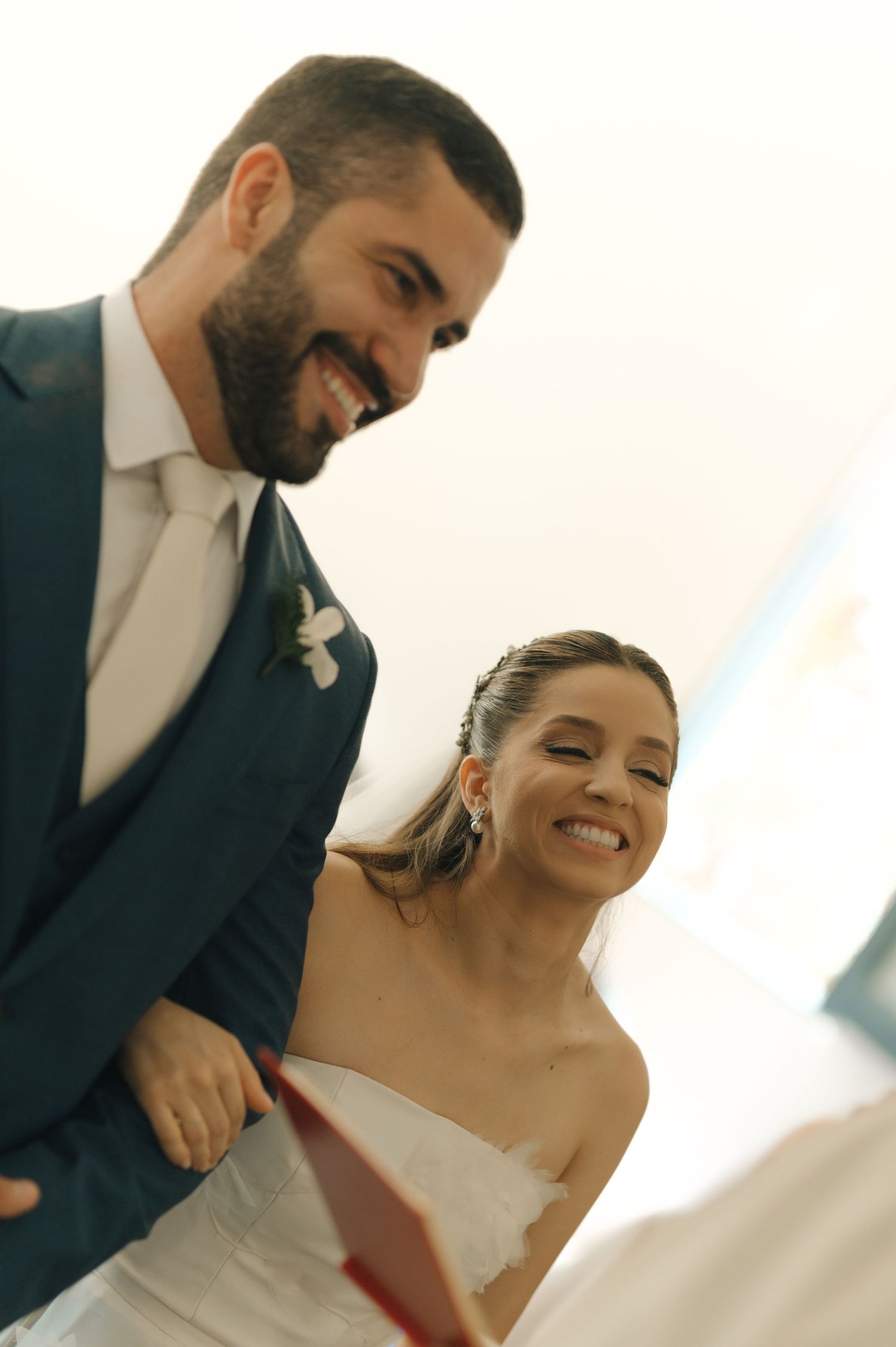 A joyful wedding moment captured in a warm and candid portrait of a couple in formal attire.