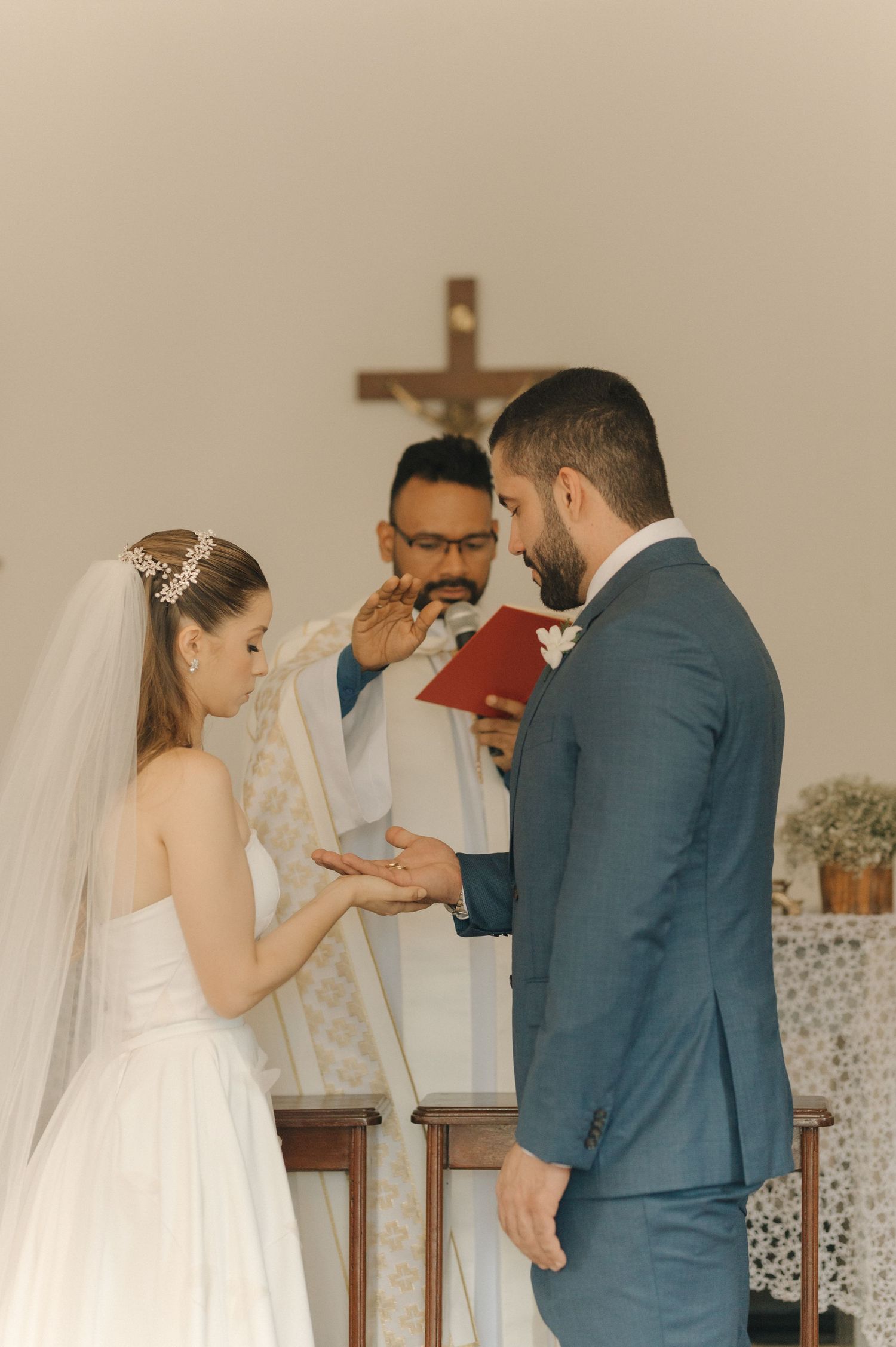 An intimate moment during the ring exchange portion of a traditional church wedding ceremony.