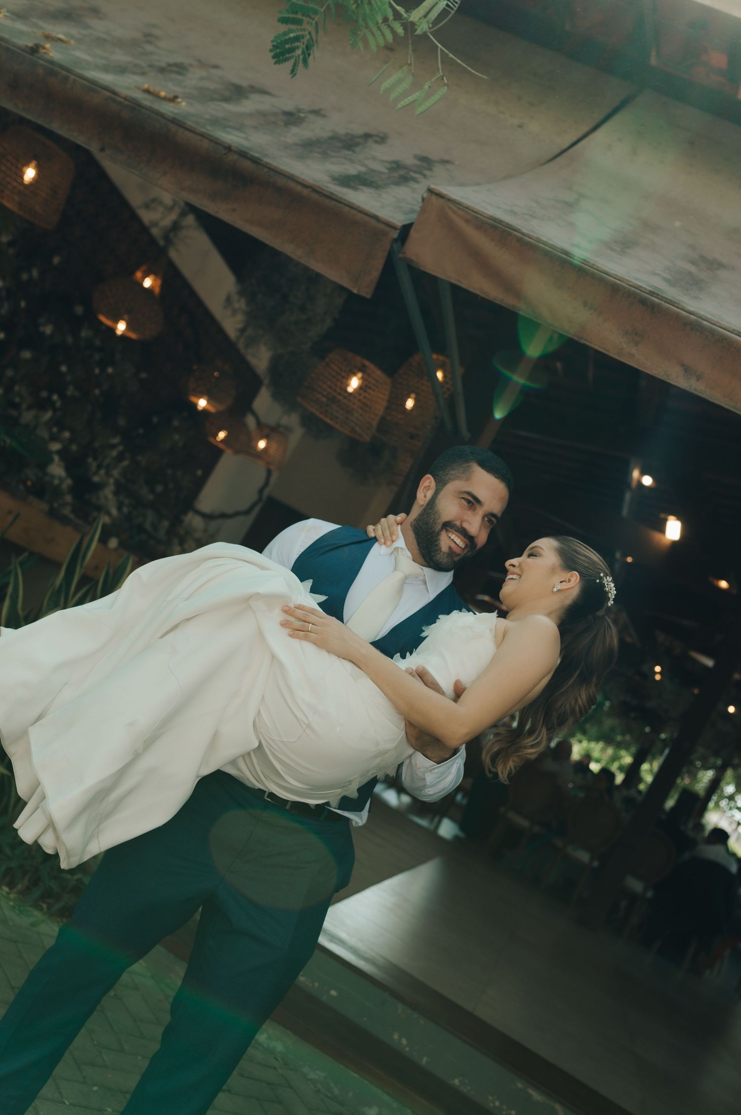 A romantic dance moment under string lights as a couple shares an intimate dip on the dance floor.