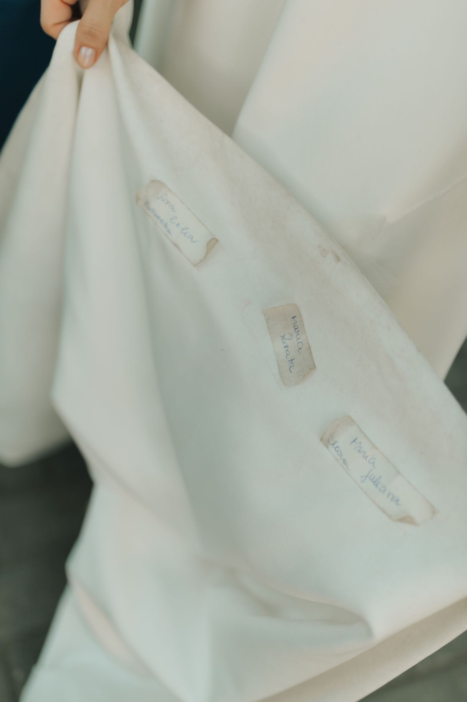 Close-up detail shot of a white wedding dress fabric with name tags sewn inside.