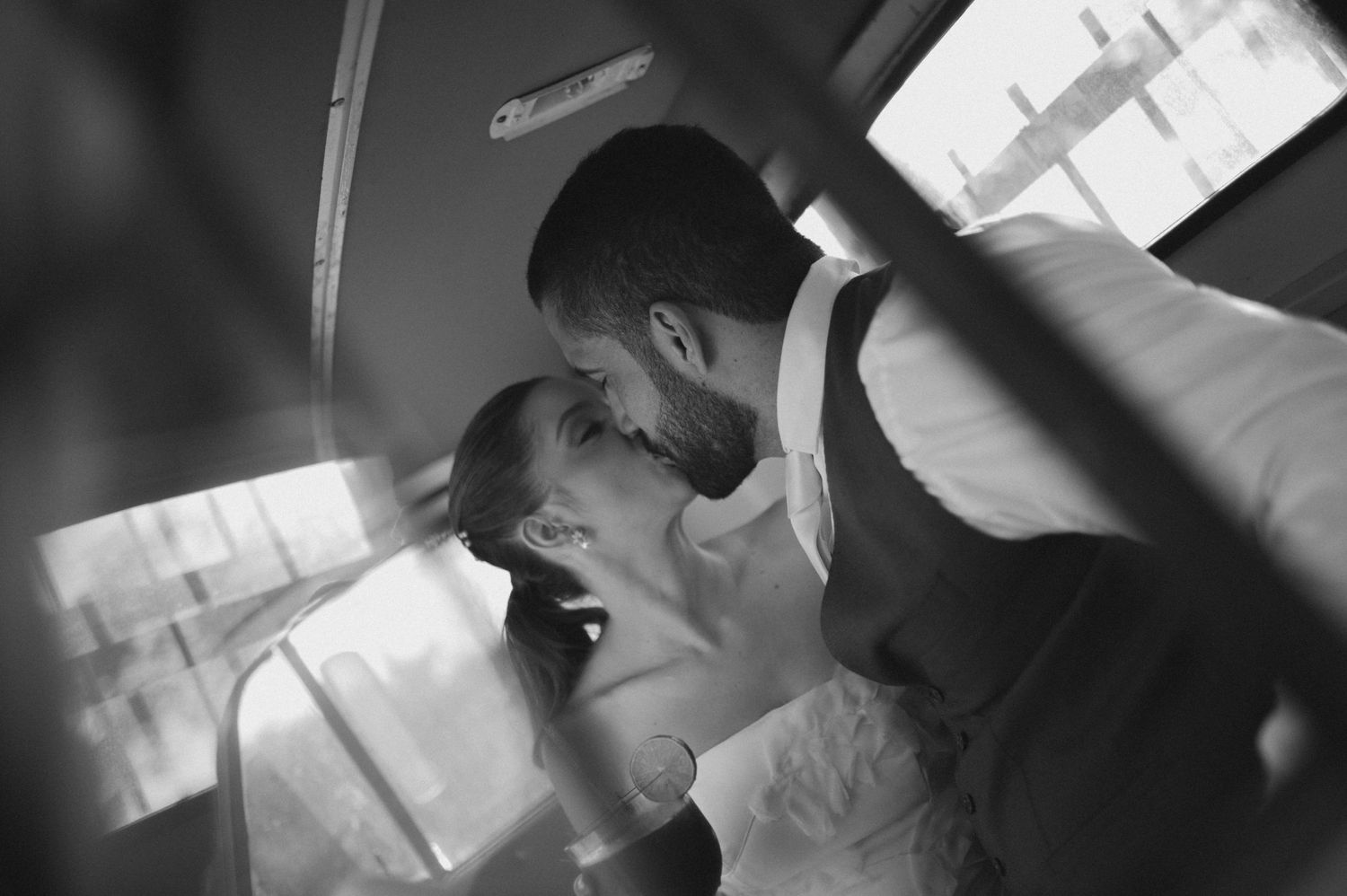 A black and white photograph showing a tender moment between newlyweds.