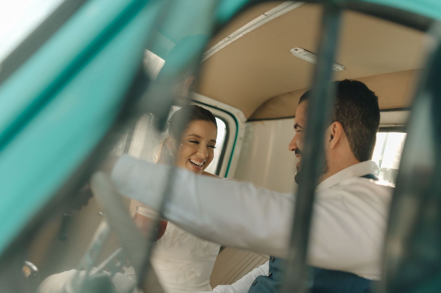 A candid moment captured through a vintage car window showing smiles and joy.