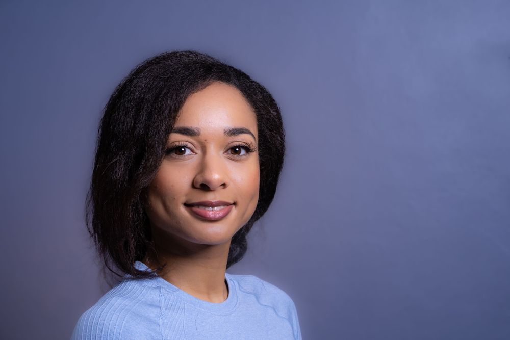 headshot portrait of a woman in Brighton wearing a blue top with dark hair