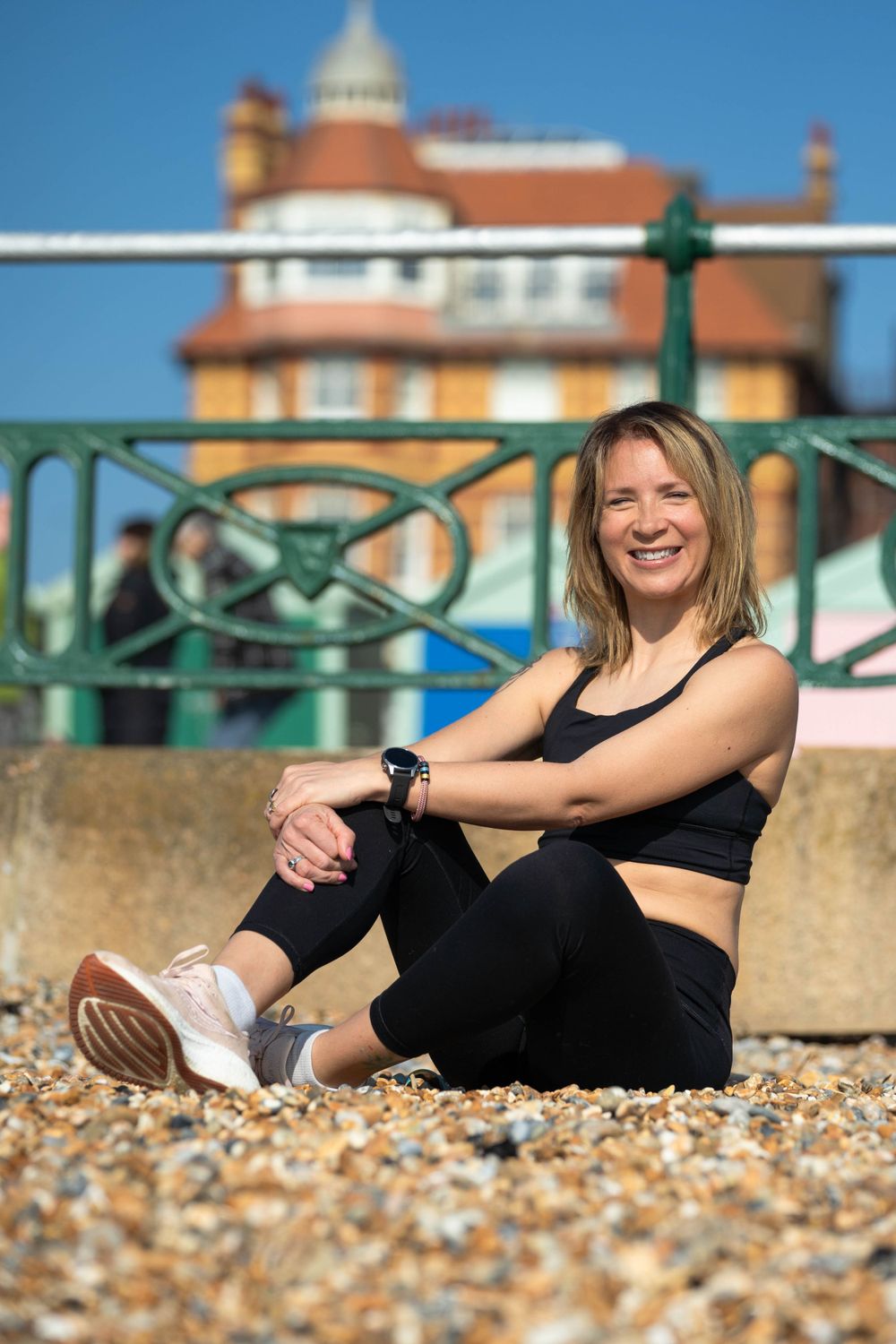 Runner sat on Brighton beach in trainers and sports wear