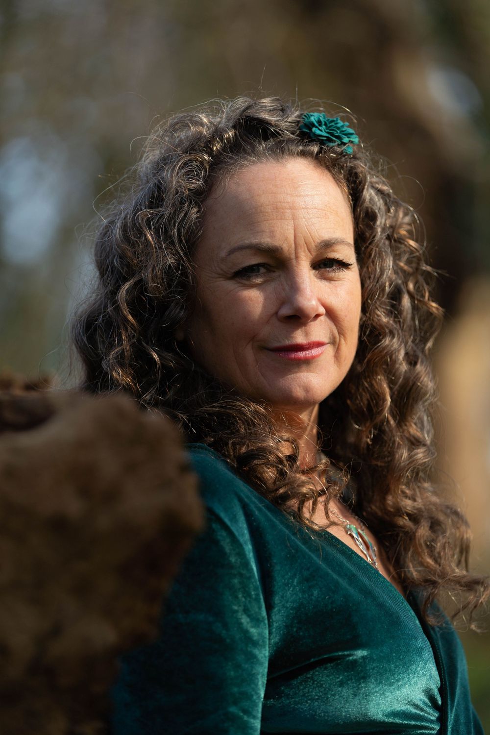 portrait of a women in the woods wearing a green velvet dress