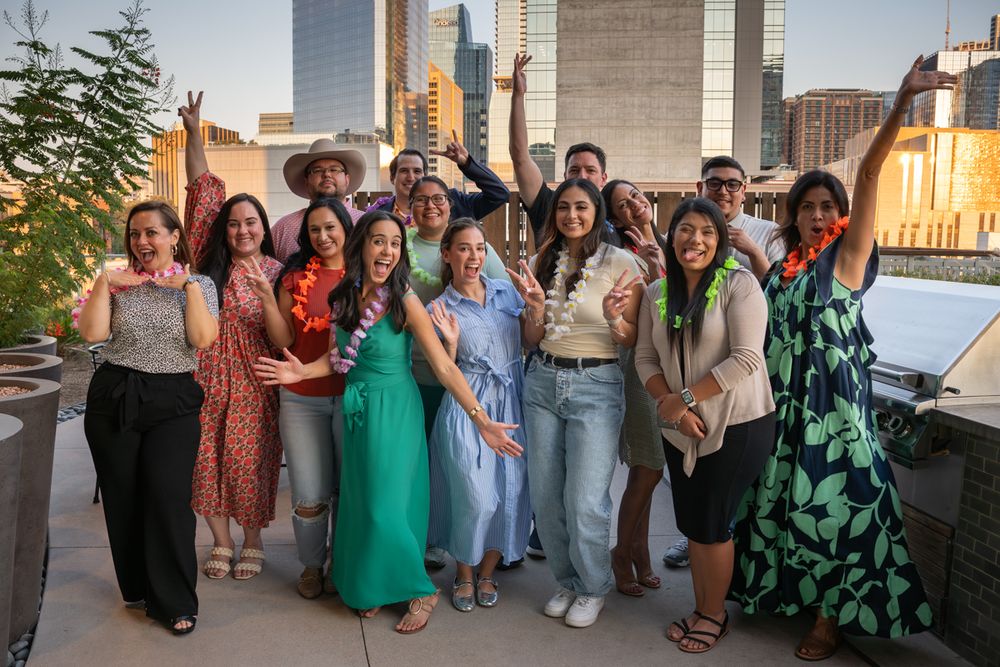 A group of friends posing together at an outdoor event during golden hour lighting.