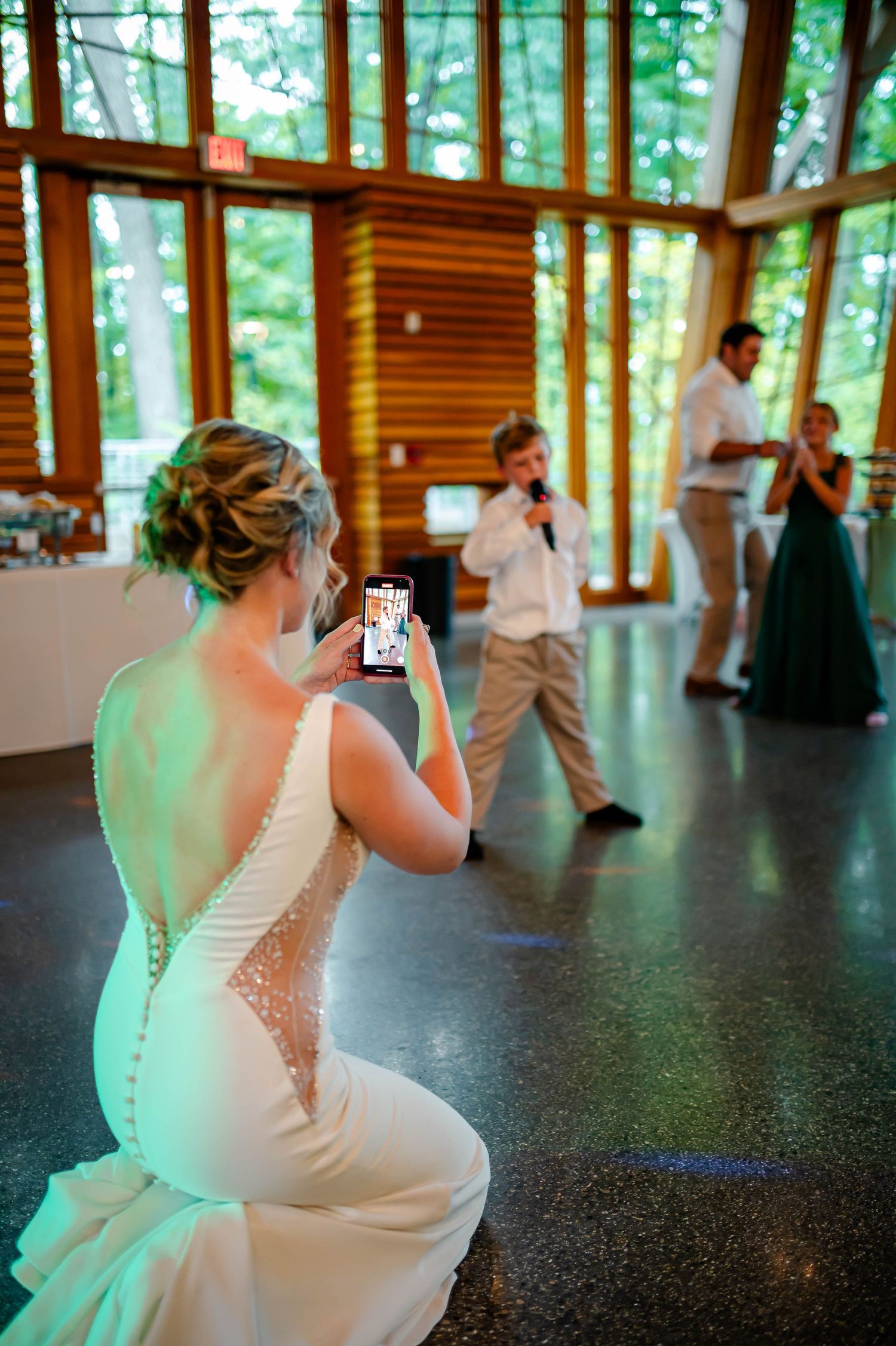 A dance floor in a rustic wood-paneled venue with a white dress visible in the background.