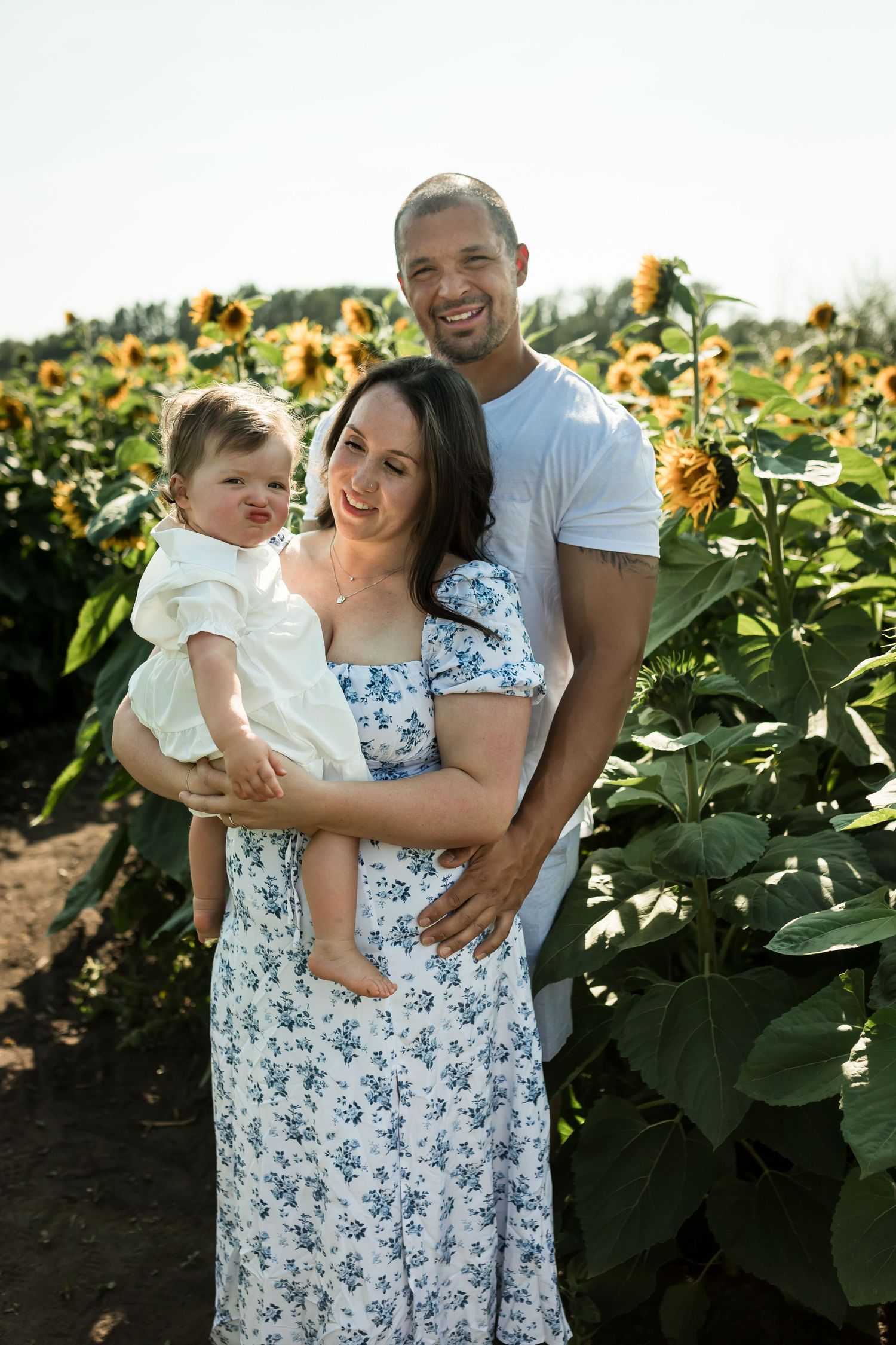 Casual lifestyle family photos in the sunflower fields at Bowden SunMaze near Calgary by Love & Sunshine Photography.