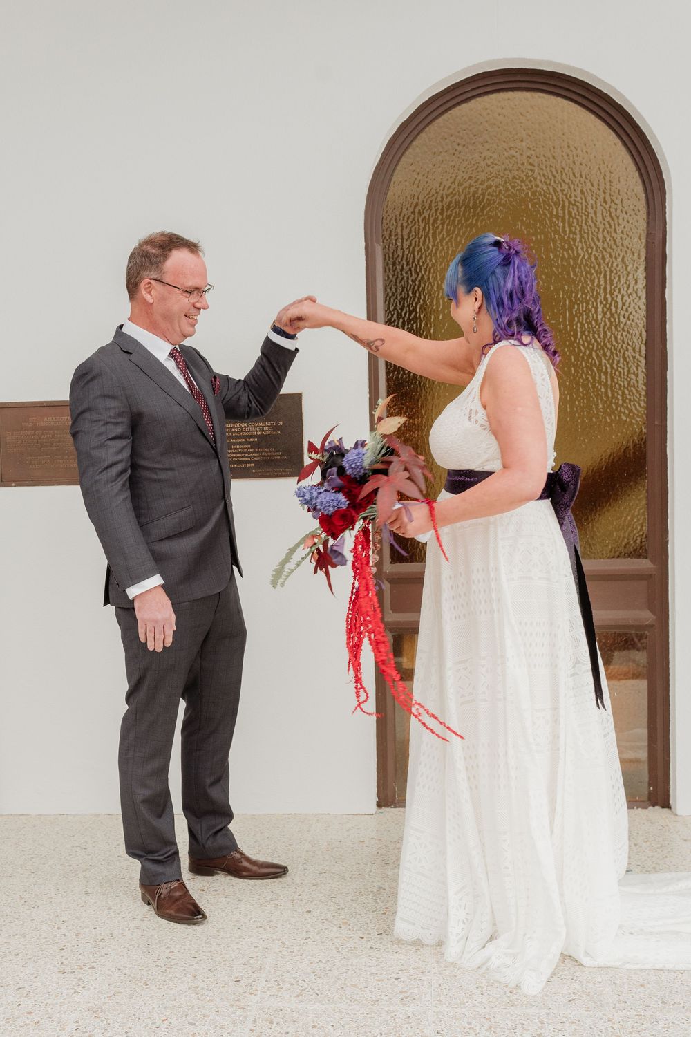 A playful sequence of wedding photos shows the bride and groom dancing with red and purple feather boas in a chic indoor venue.