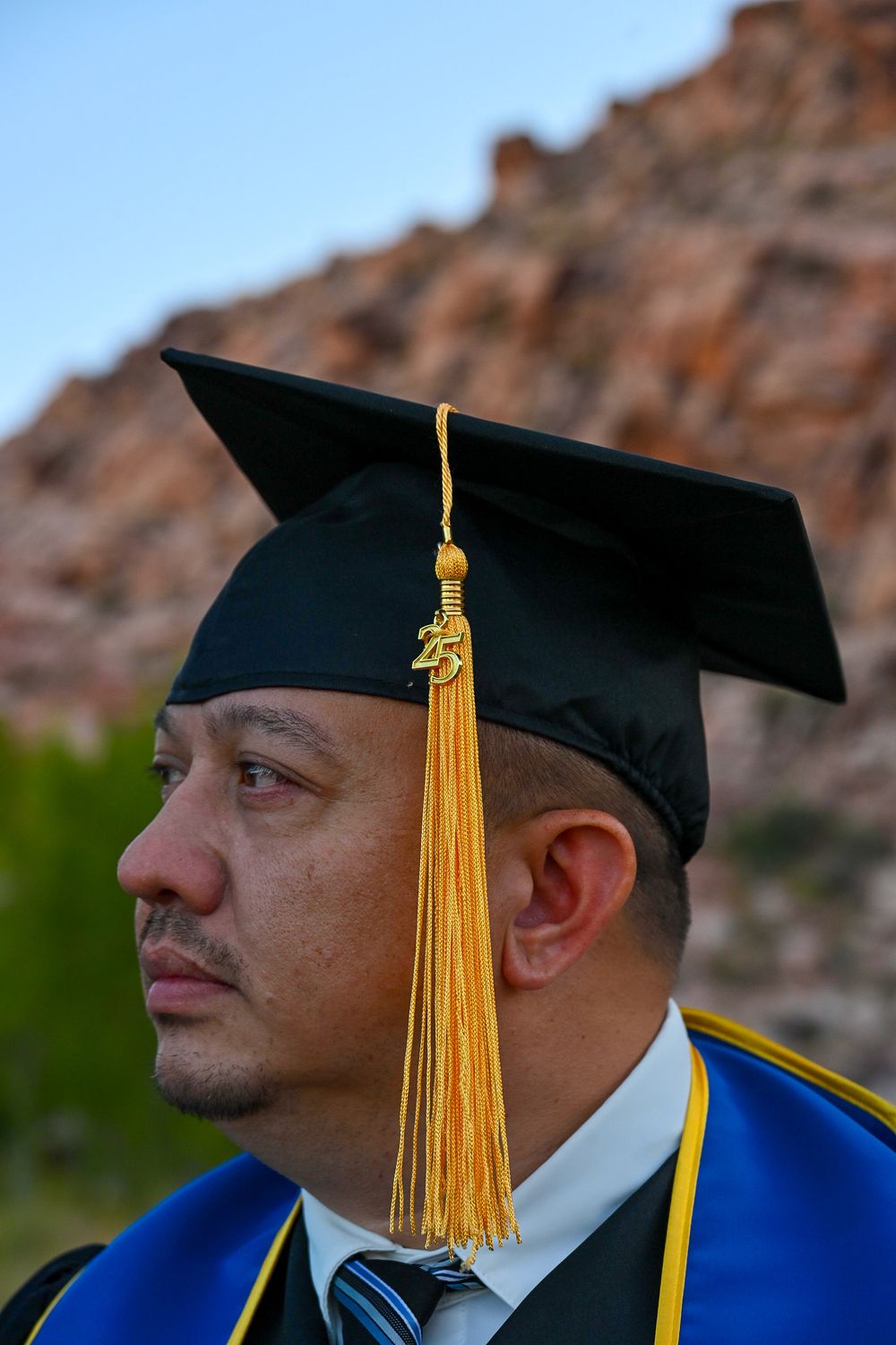 Close-up profile of a male veteran in black graduation cap with gold tassel from Arizona College of Nursing BSN Class of 2025.