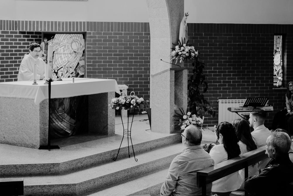 Church interior with wooden pews and brick walls during a special ceremony.