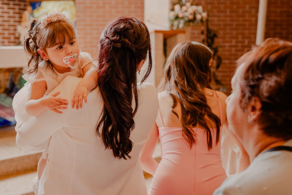 Guests in formal attire seated in church pews during a ceremony.