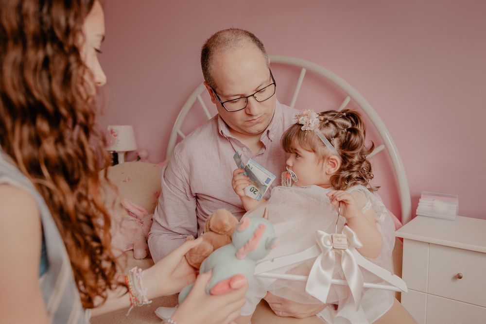 Tender family moment captured in soft pink tones during a special celebration.