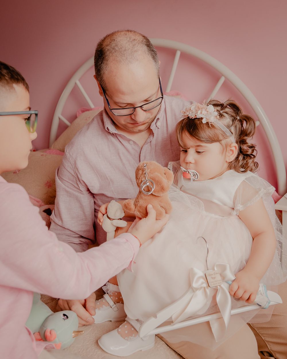 Sweet family bonding moment in a pink-themed nursery setting.