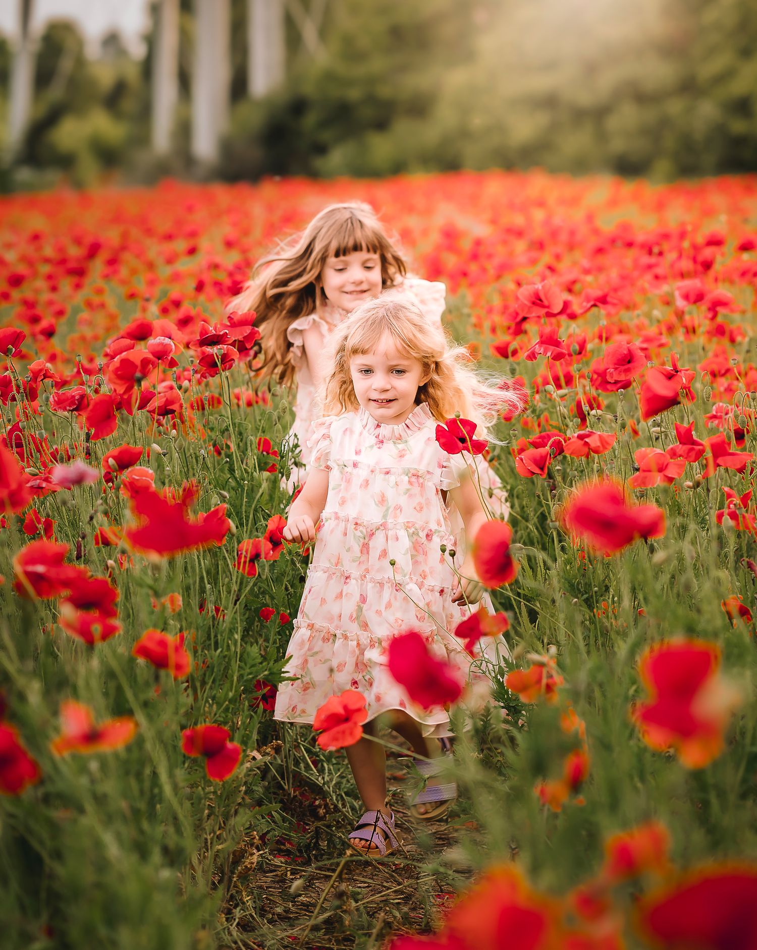 A child in a floral dress runs joyfully through a vibrant field of red poppies on a sunny summer day.