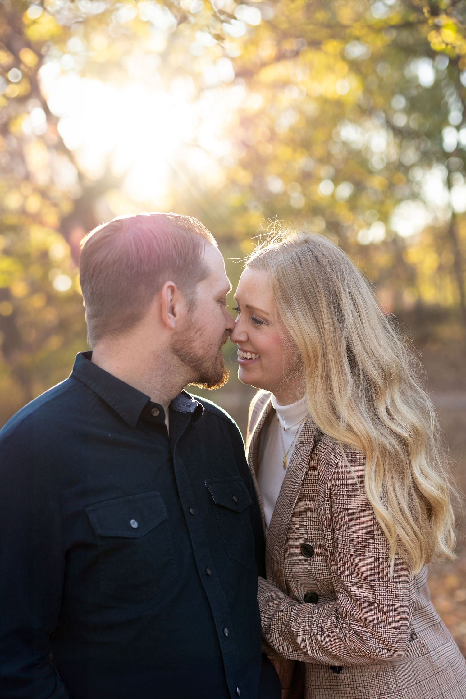 Romantic photo of couple outside under a golden light coming through the trees