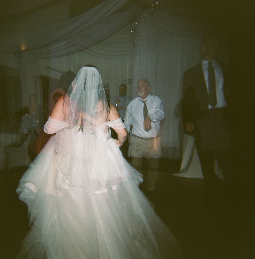 120mm double exposure photo of the bride and guests dancing at their reception in the winter in downtown Portland, Maine.