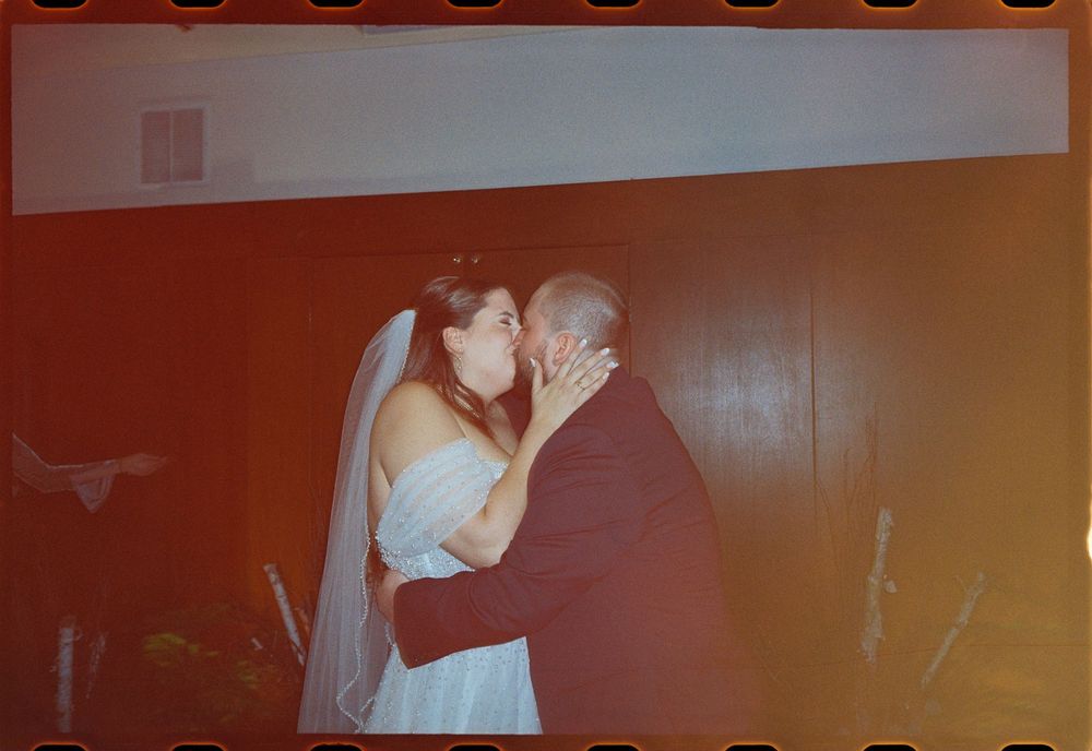 Vintage film photo of couple kissing each right other after their wedding vows at The Regency Hotel in downtown Portland, Maine.