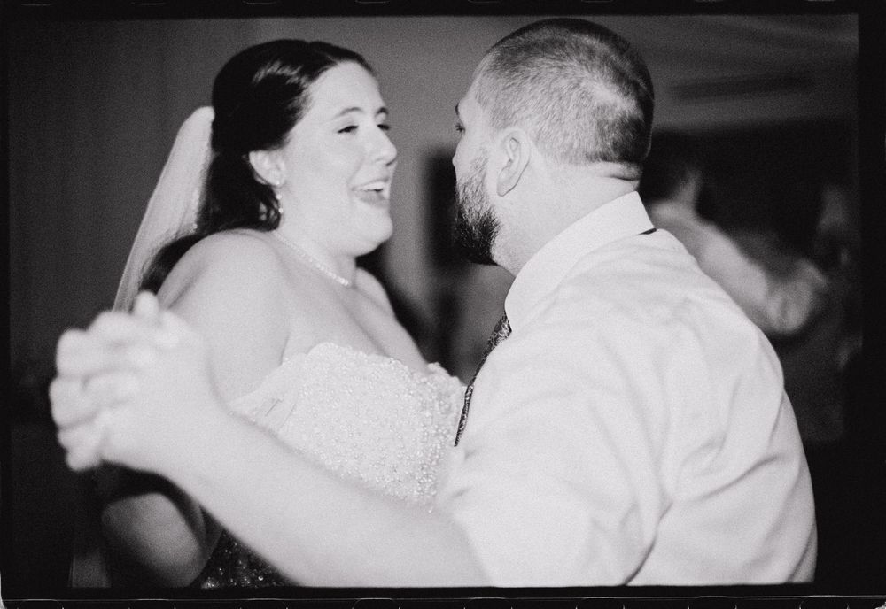 Couple singing and dancing together on black and white film at their winter wedding in downtown Portland, Maine.