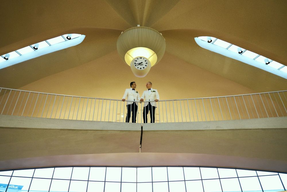 Contemporary building interior with curved design elements and natural lighting from skylights. gay couple wedding  TWA hotel