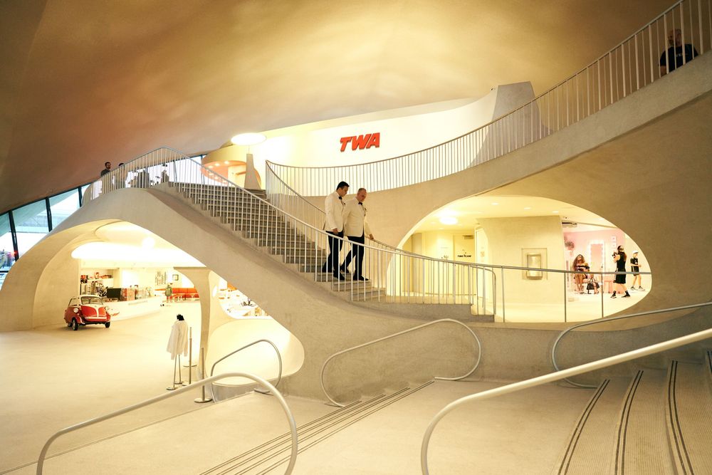Curved architectural space with flowing lines and modern lighting design elements. gay couple wedding  TWA hotel