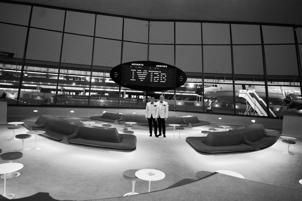 Dark panoramic view of a modern terminal or lobby space with geometric design elements. gay couple wedding  TWA hotel
