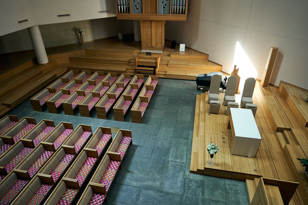 Modern church interior with wooden pews and blue carpeting. Siant peters church